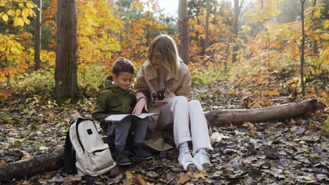 mother and son sitting at the forest