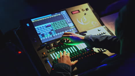 lighting technician operating a lighting console