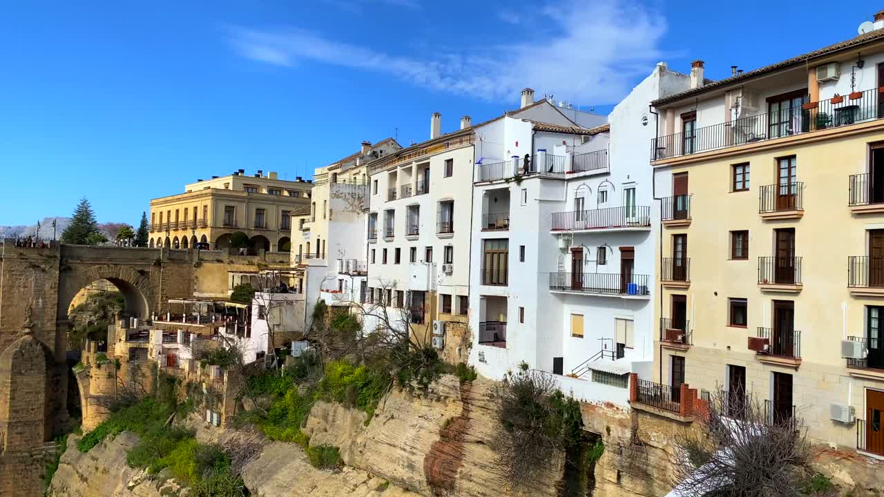 Smuk blå himmel og byudsigt på den historiske Puente Nuevo-bro i Ronda, Spanien, 4K panorering mod venstre