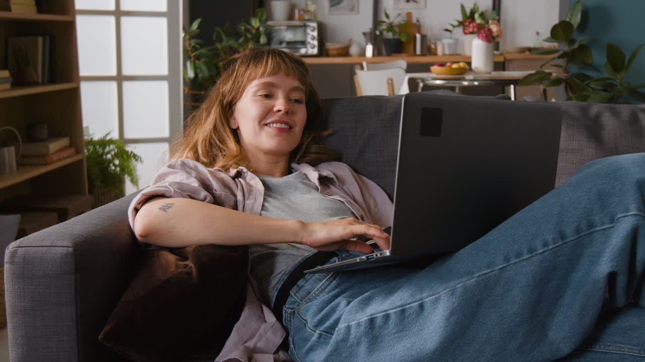 Woman relaxing on couch with laptop