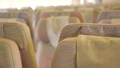 asientos de avión de pasajeros purpurados vacíos en la cabina,
