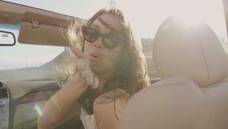 mujer feliz disfrutando de un paseo en coche convertible en un día soleado