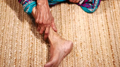 close up on senior women feet and hand massage on injury spot