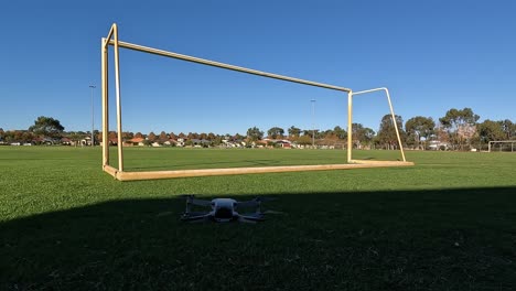 vista de un dron despegando y volando a través de la portería de fútbol y a través del campo