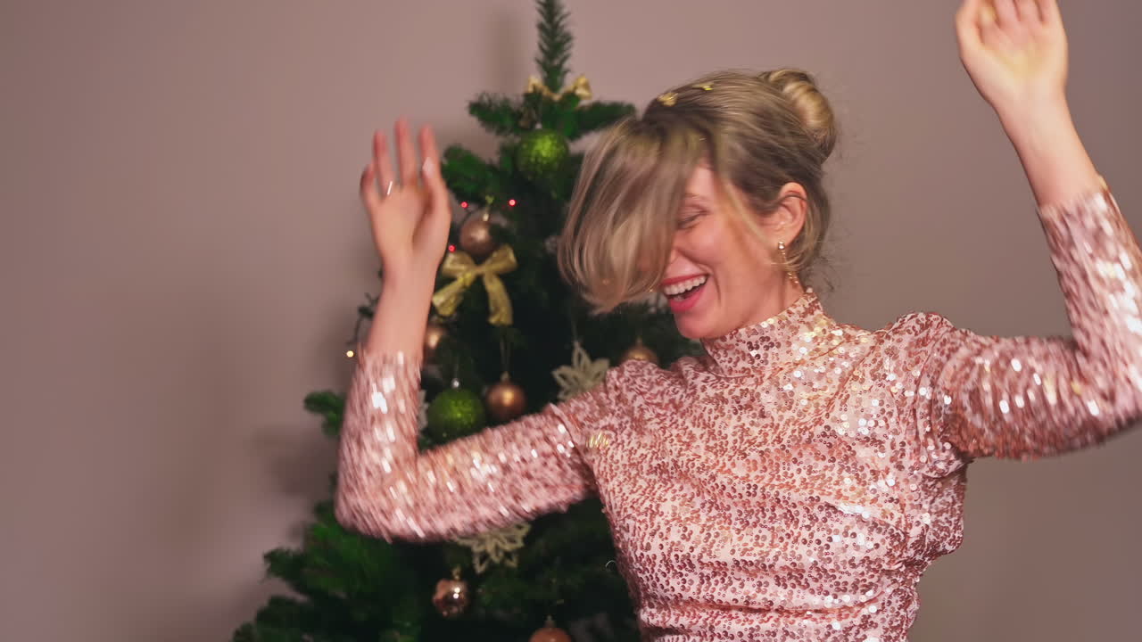 Young dressed woman dancing in front of a christmas tree