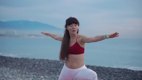 mujer practicando yoga en una playa