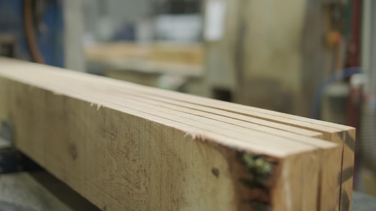 Macchina industriale che taglia una trave di legno in assi in una segheria