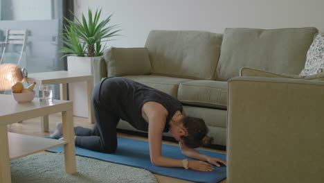 Women-kicks-over-table-lamp-while-trying-to-work-out-in-her-cluttered-living-room