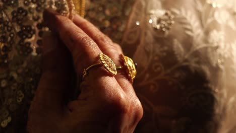 woman's hand with traditional gold ring and embroidered dress
