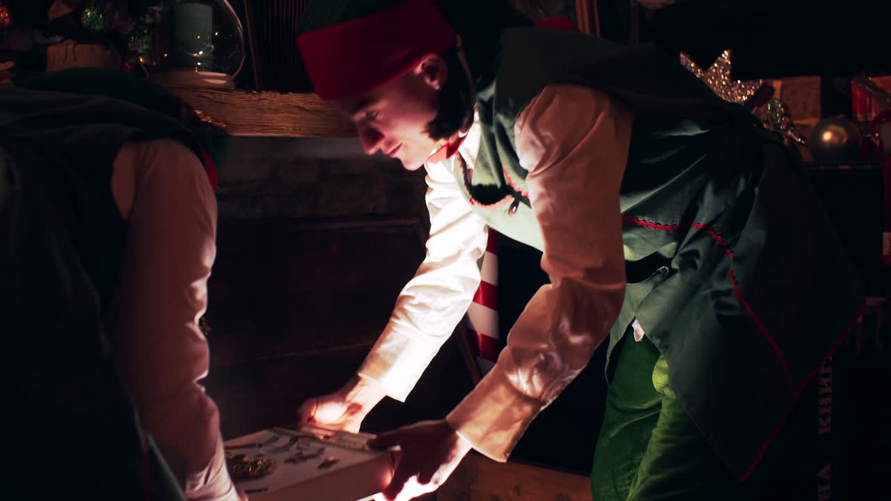 Christmas Elves open a sparkling treasure chest in Santa Claus's house