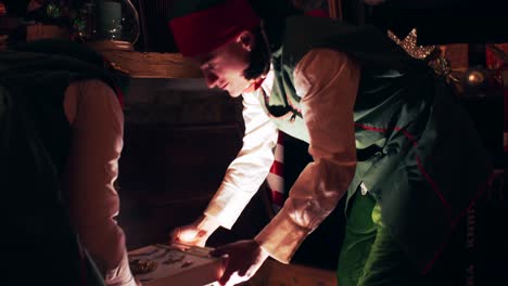 christmas elves open a sparkling treasure chest in santa claus's house