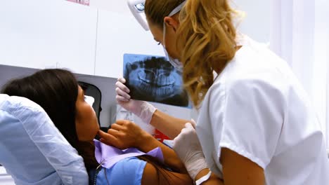 Dentist-discussing-x-ray-with-female-patient