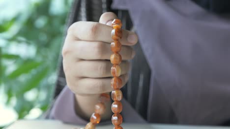 woman praying with prayer beads