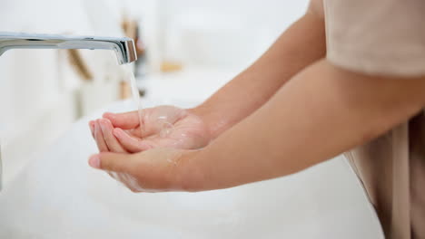 person, water and washing hands in sink