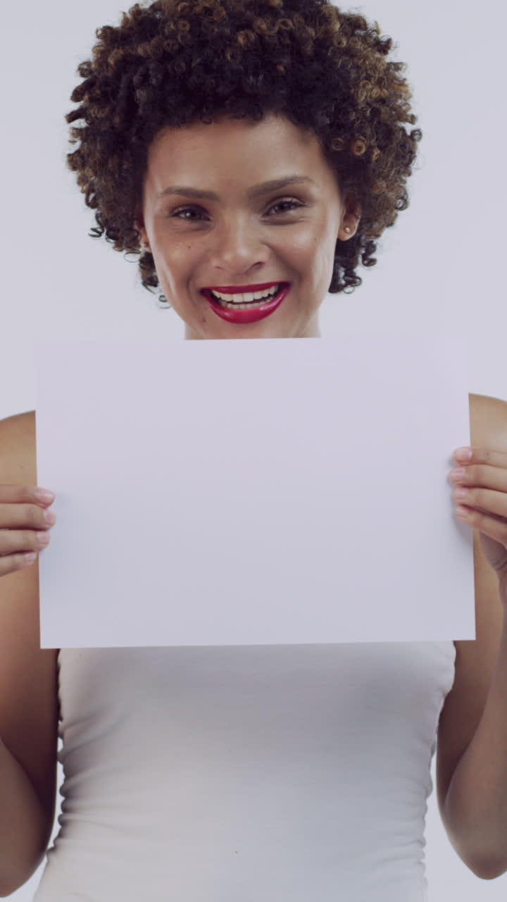 Donna felice che regge un cartello bianco vuoto in studio