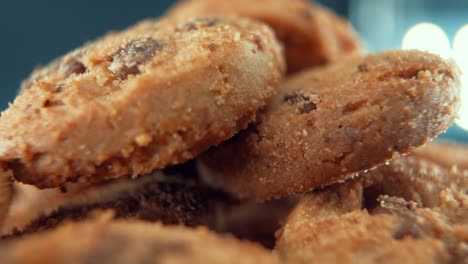 a macro close up cinematic shot of a plate full of crispy chocolate chip cookies, on a 360 rotating stand, studio lighting, super slow motion, 120 fps, full hd video