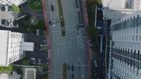 Top-down-panning-view-of-wide-multilane-trunk-toad-leading-between-modern-high-rise-buildings-in-urban-borough.-Miami,-USA