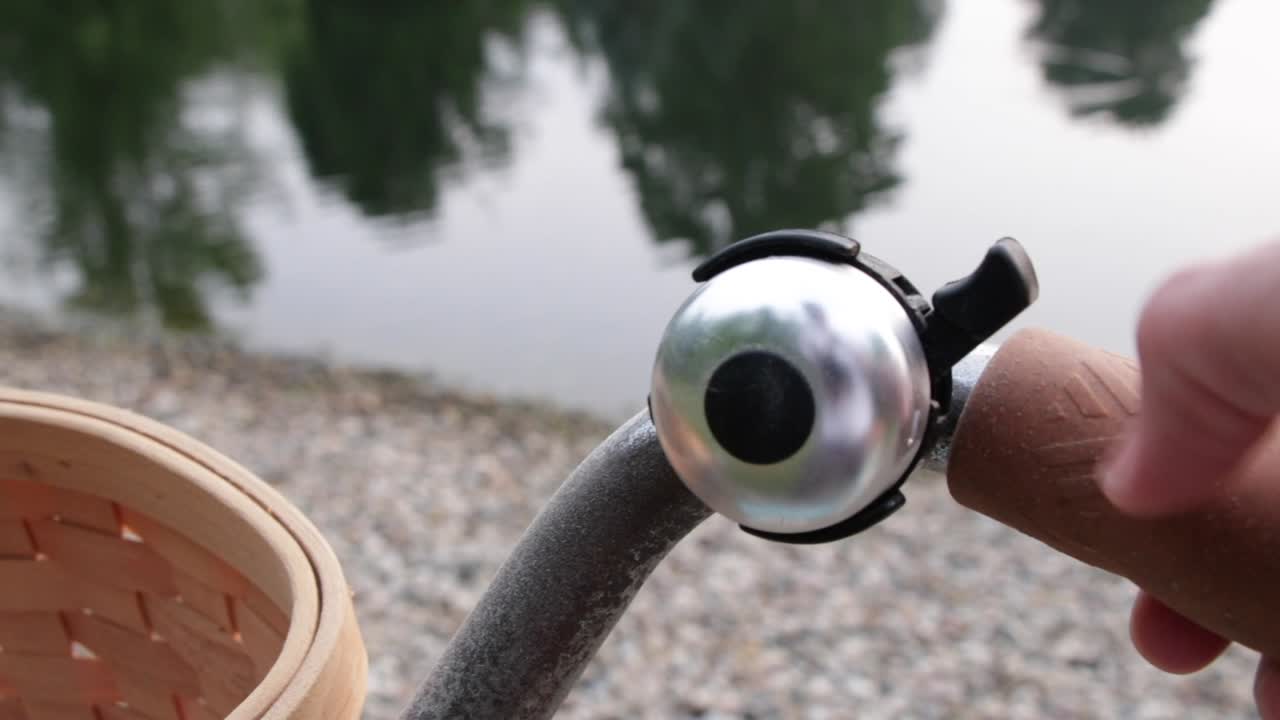 교외나 시골 호숫가에 바위와 물이 있는 연못 근처에 빈티지 종소리가 울리는 오래된 파란색 자전거