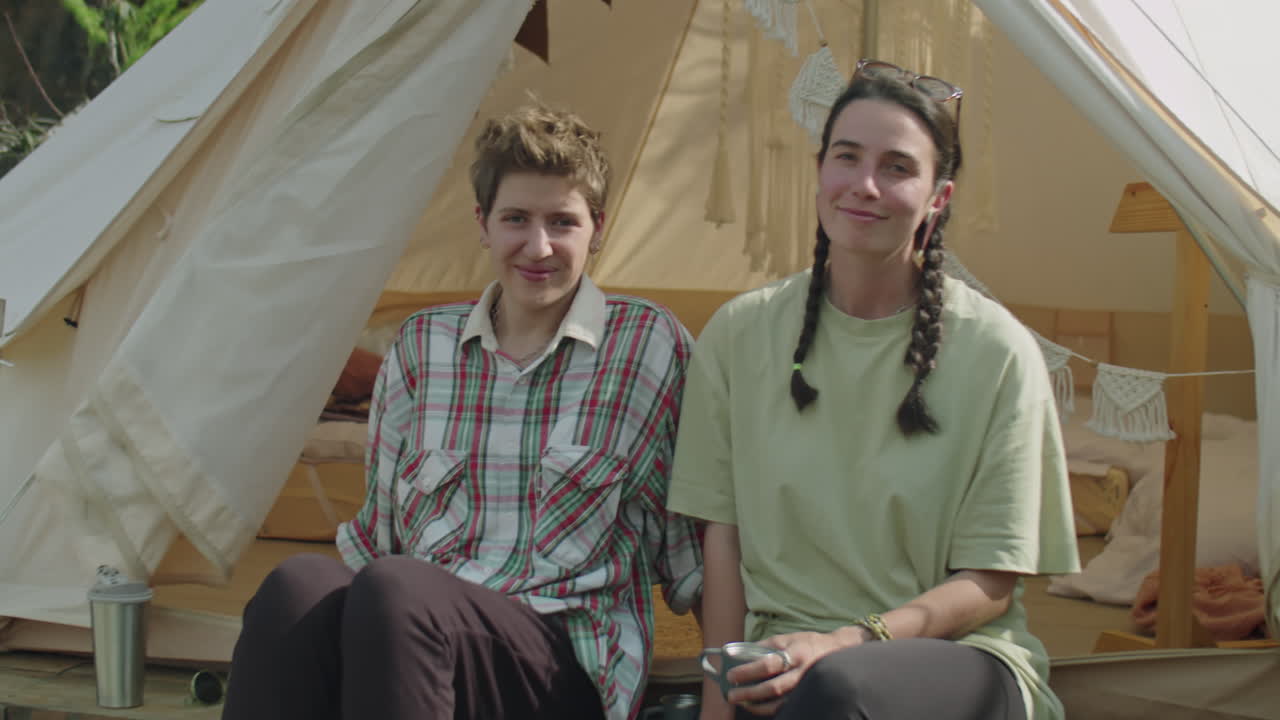 Portrait of Two Joyous Female Tourists in front of Glamping Tent