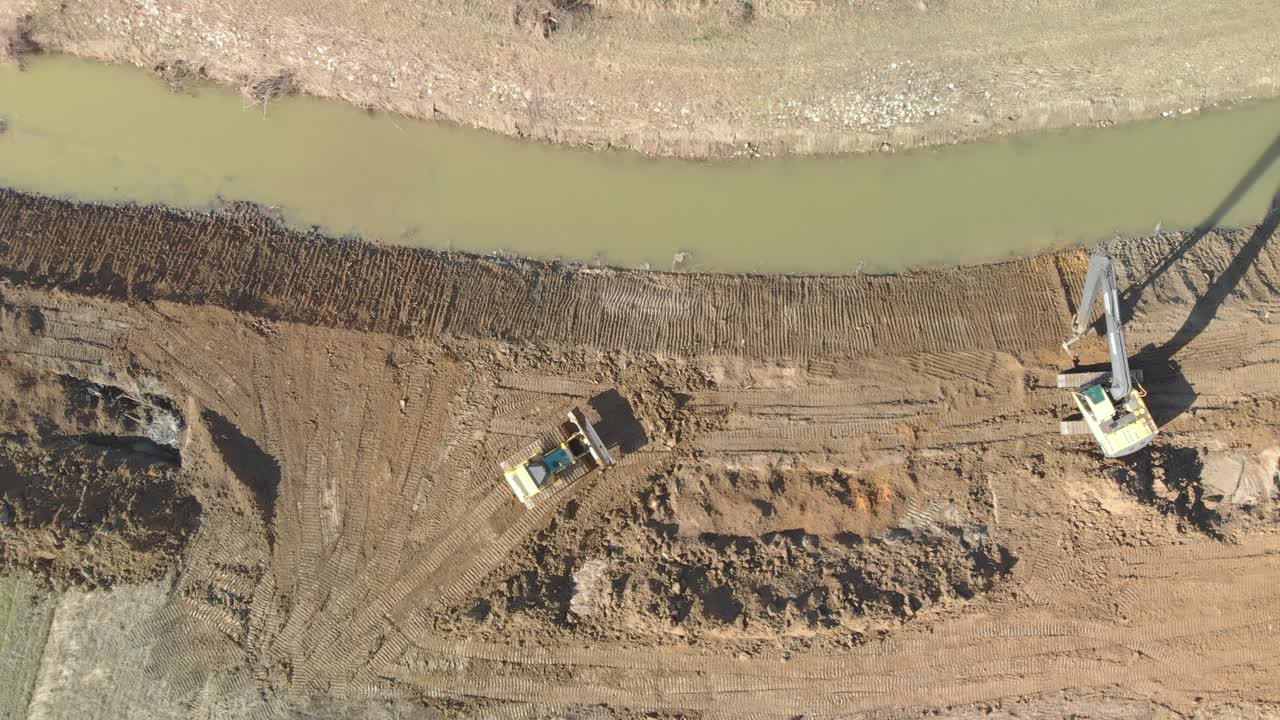 Aerial static shot of excavators widening river channel