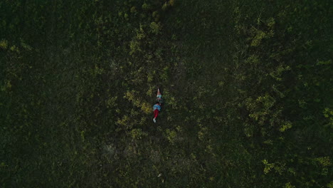 Aerial-view,-drone-and-people-lying-on-grass