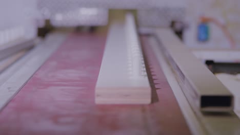 close-up of a boxspring bed slat on machinery in a production line, shallow focus