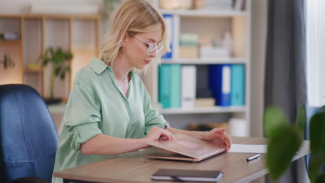 Woman-Opens-Laptop-and-Starts-Working-at-Desk