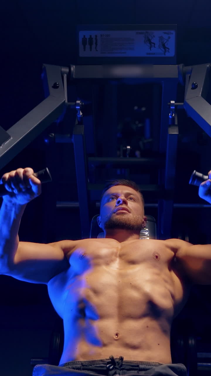 Bodybuilder working out in gym. Strong man during exercise with work out program for healthy. Vertical video