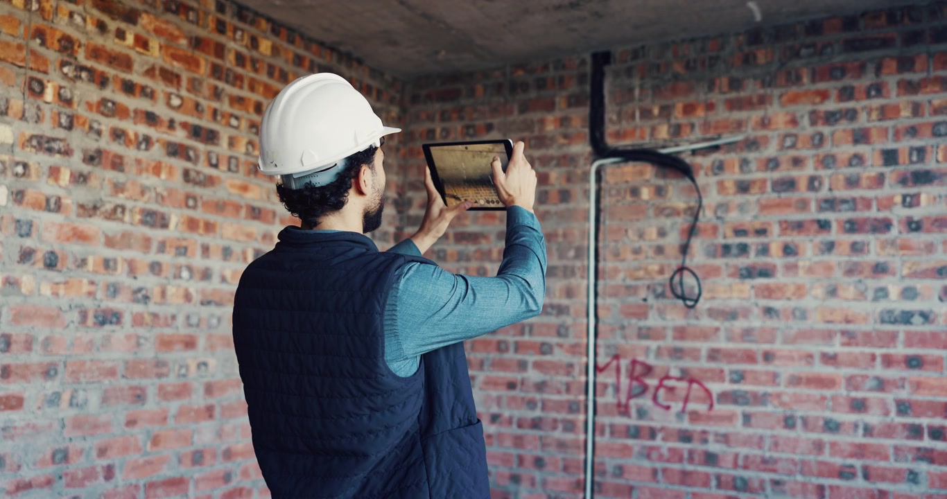 Construction Worker Using Tablet to Inspect Building Site