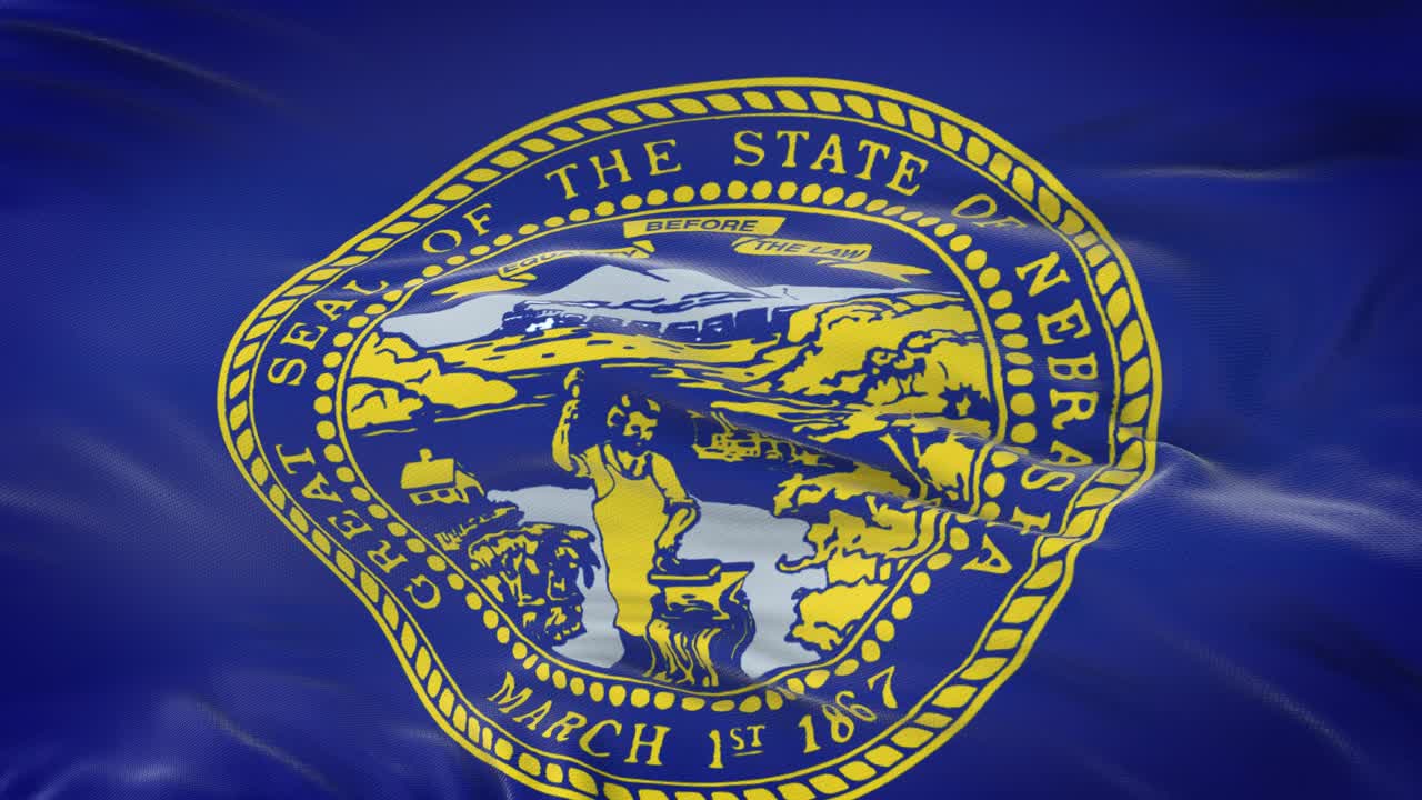 la bandera de nebraska (estado de los estados unidos) ondeando en el viento con una textura de tela muy detallada. bucle sin costuras