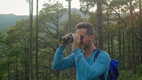 happy man admiring nature through binoculars