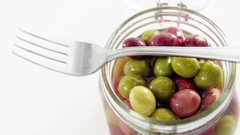 un frasco lleno de aceitunas en vinagre