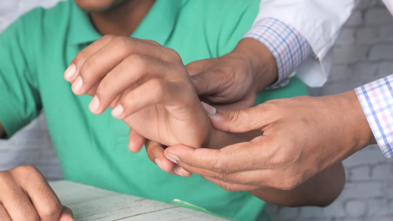 Medico che esamina la mano di un paziente
