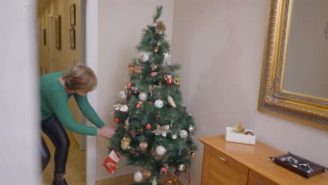 mujer decorando un árbol de navidad