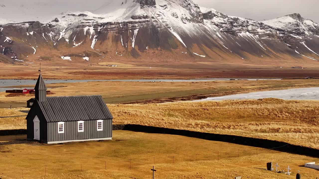 Búðakirkja, the iconic black church of Búðir, stands starkly against the dramatic backdrop of Iceland's Snæfellsnes Peninsula. This charming wooden church, has a striking dark facade.