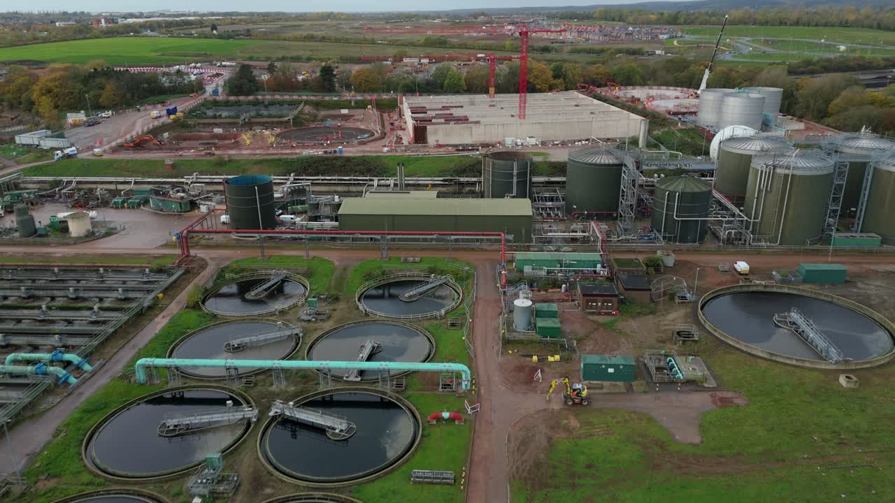Aerial drone video of major wastewater treatment plant with tanks, silos, circular clarifiers and industrial structures near Leicester United Kingdom