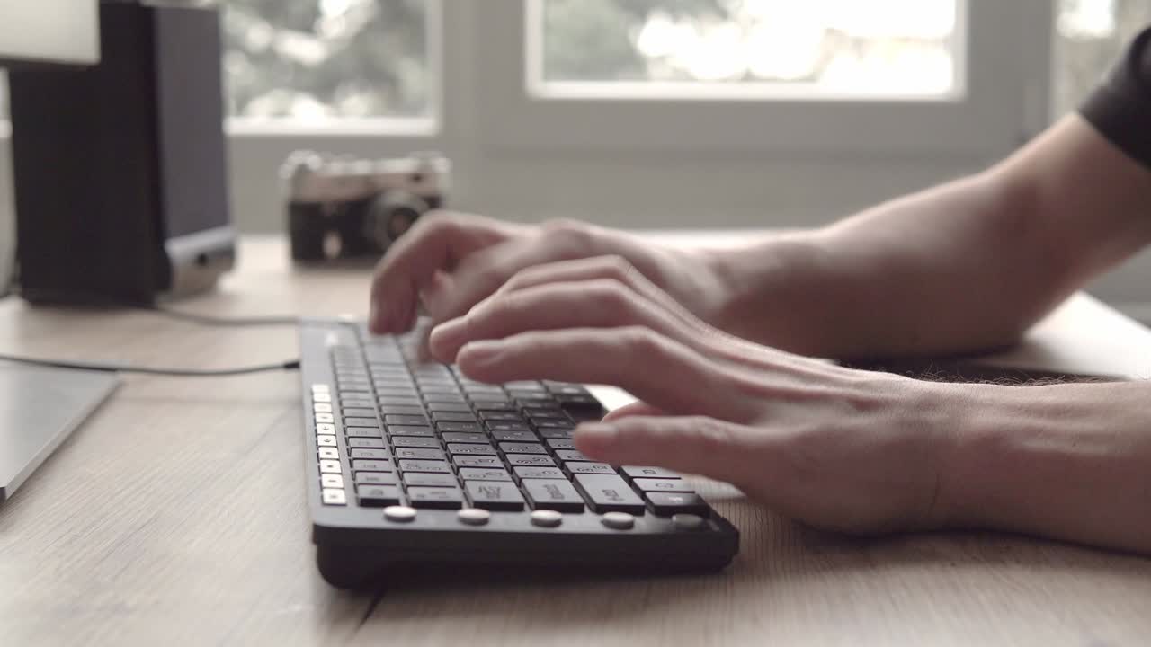 молодой человек, пишущий на клавиатуре, а затем использующий планшет. фотограф-фрилансер, работающий и использующий планшет для общения с клиентами.