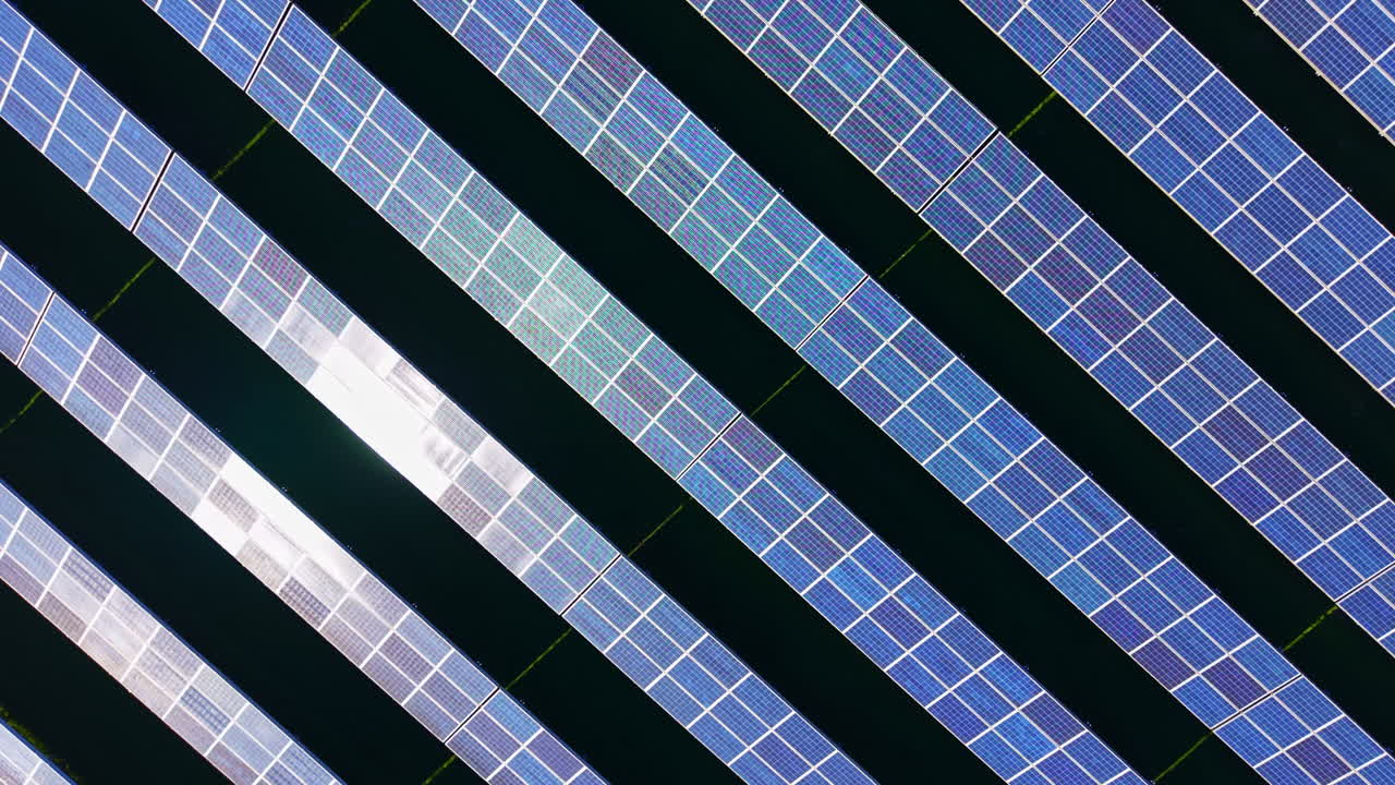 Pannelli solari disposti in file catturano la luce solare in un impianto di energia rinnovabile nel pomeriggio per generare elettricità per la comunità locale.