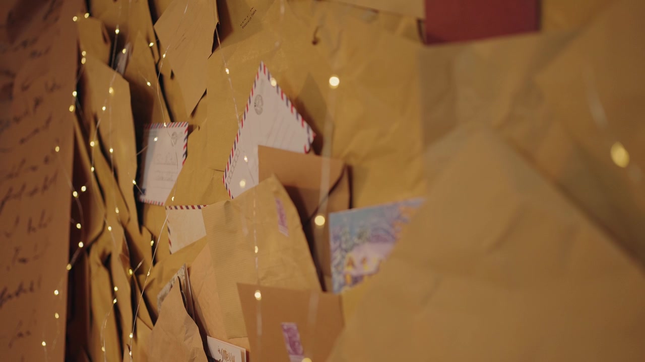 Christmas letters and postcards stacked with warm lights, creating a festive mood