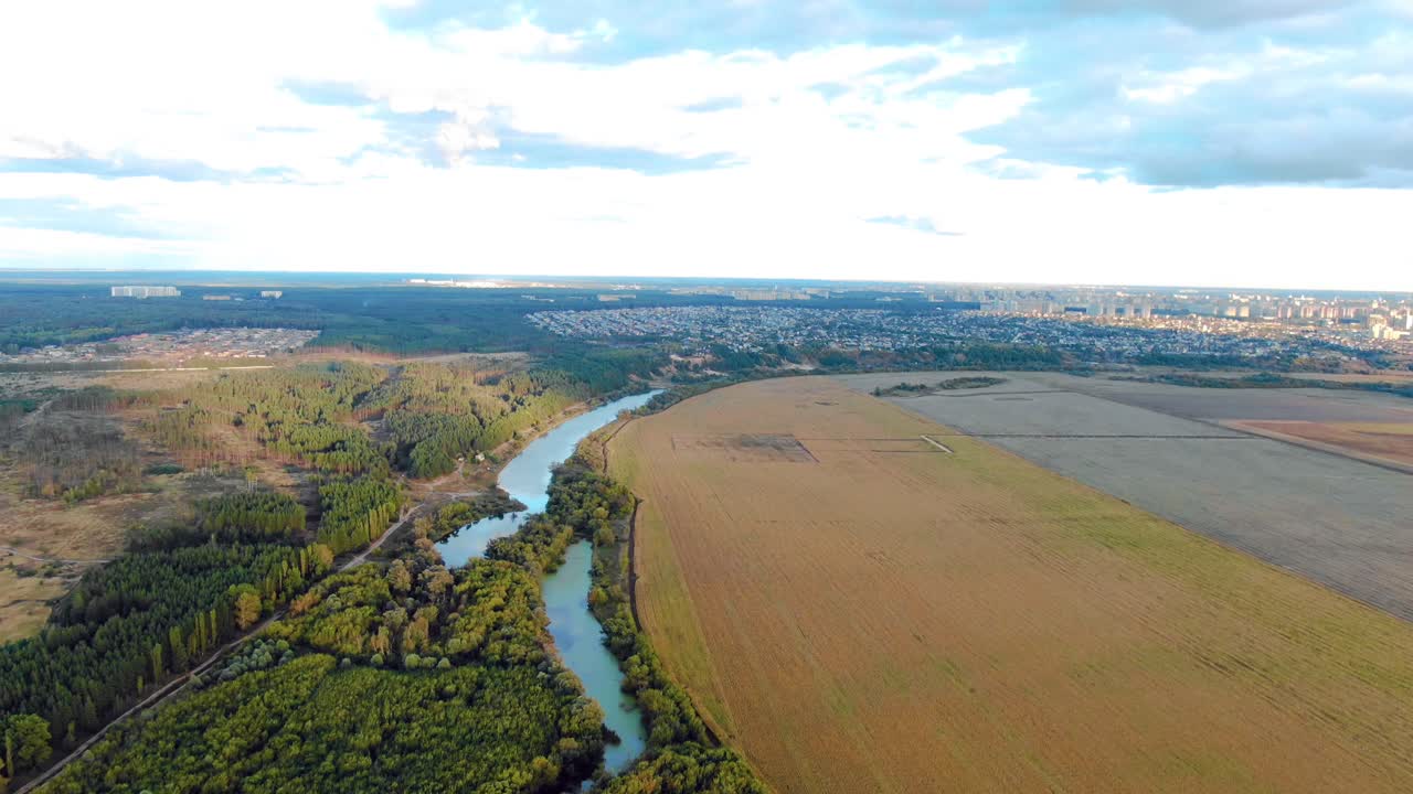 도시를 배경으로 시골 풍경을 가로질러 흐르는 강의 공중 풍경.