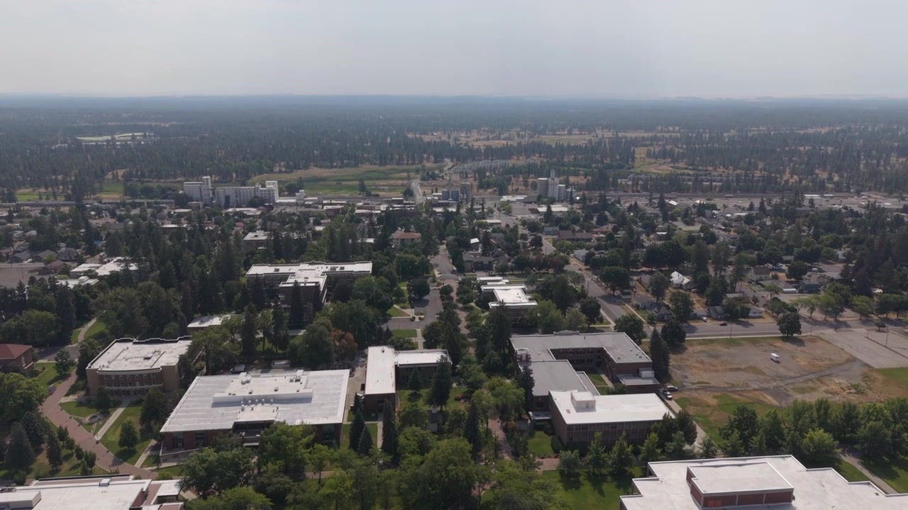 Veduta aerea del campus della Eastern Washington University, con edifici accademici, strutture per studenti e quartieri circostanti. Ripresa con drone in avanzamento e inclinazione verso l'alto