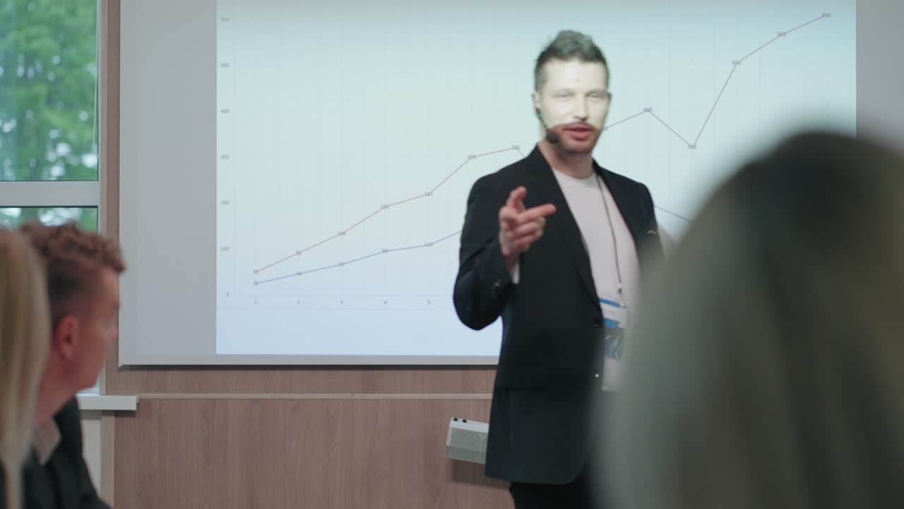 guapo y confiado entrenador de negocios está hablando en una conferencia de negocios caminando contra la exhibición