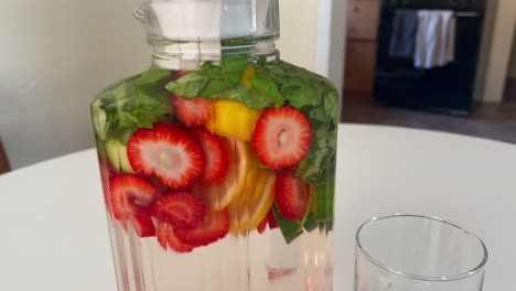 healthy drinks in the kitchen, push in shot of fruit infused spa water on white table