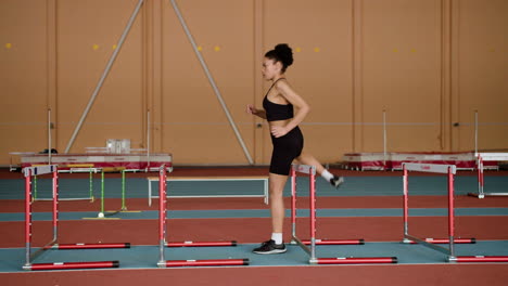 female athlete jumping hurdles