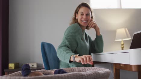 Video-of-happy-caucasian-mother-working-on-laptop-from-home-with-newborn-baby