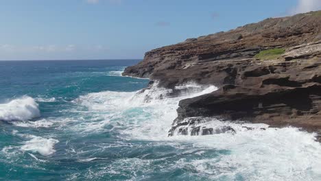 Vista-Aérea-De-Las-Olas-Rompiendo-En-La-Costa-Rocosa-Frente-A-La-Ensenada-De-Kahauloa