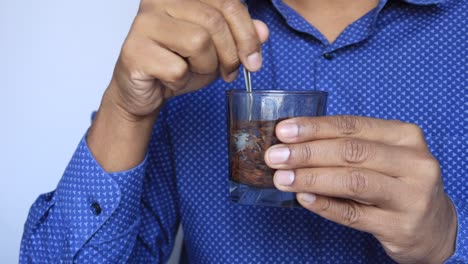 hombres jóvenes poniendo semillas de chía en un vaso de agua