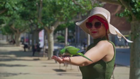 stunning video of parrots eating seeds from the hand of a caucasian girl in green dress with a knitted hat