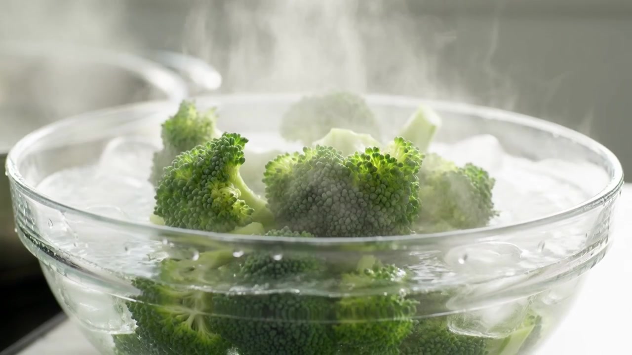 Uno chef che sbollenta broccoli freschi in un bagno di acqua ghiacciata