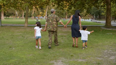 military man enjoying leisure time in park with his family